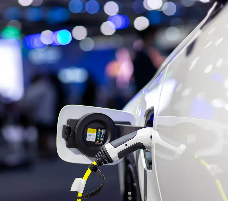 Charging cable plugged into the port of a white electric car