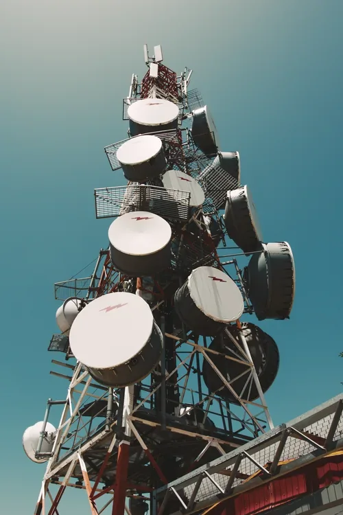 Microwave dishes on a telecom tower against a blue sky
